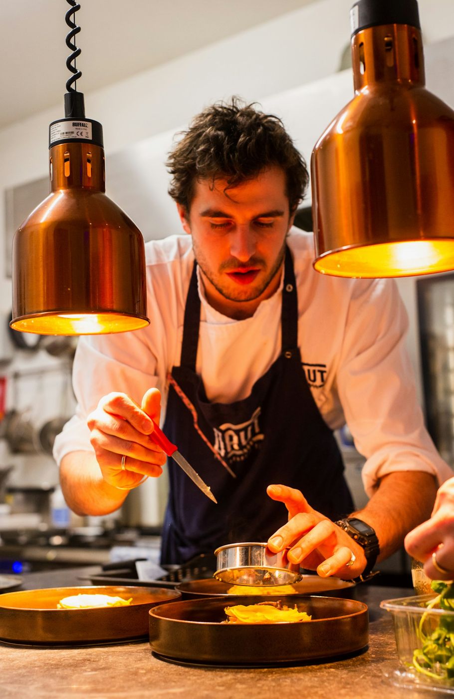 Illustrative chef portrait in a working kitchen